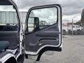 The image shows the open driver's door of a 2015 Mitsubishi Fuso FE160 with a gray interior and a visible seat inside