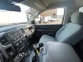 Interior of a 2016 RAM 5500 featuring a driver's seat with gray upholstery a dashboard with controls and a gear shift in the center console