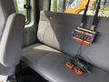 A 2011 International 4300 truck's interior featuring a gray bench seat with a mounted tool organizer and two battery packs on the seat