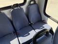 Interior seating of a 2014 Chevrolet Express with three upholstered blue seats featuring seatbelts and handles