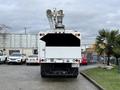 A white 2015 Freightliner M2 bucket truck positioned with its boom raised ready for use