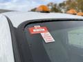 A 2012 Ford F-550 with a certificate of approval sticker affixed to the windshield displaying various months and a unique identification number