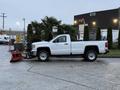 A 2017 GMC Sierra 3500HD pickup truck with a snow plow attachment parked on a paved surface