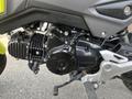 A close-up view of the engine and transmission components of a 2018 Honda Grom showcasing the black casing and silver framework