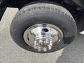 Close-up of a chrome wheel rim mounted on a tire labeled Wrangler HT on a 2004 Ford Econoline
