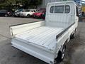 A white 2010 Daihatsu Hijet pickup truck featuring an open cargo bed and minimalistic design