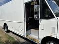 A white 2012 Ford Econoline box truck with an open door showing the driver’s seat and steps leading into the cabin
