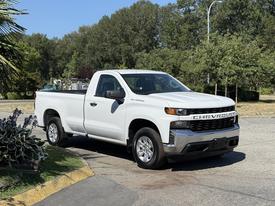 A white 2021 Chevrolet Silverado 1500 pickup truck parked with a single cab and a standard bed visible on the side