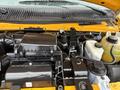 Close-up of the engine compartment of a 2021 Ford Econoline showing various components like the air intake, coolant reservoir, and electrical connectors