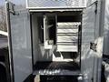 An open storage compartment of a 2008 Kenworth T370 featuring shelves and hooks for organizing tools and equipment