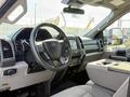 Interior of a 2021 Ford F-250 SD featuring a modern dashboard a steering wheel with controls and a central console with storage space