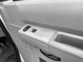Close-up of the interior door panel of a 2010 Ford Econoline featuring power window controls and textured design elements