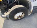 Close-up of the front tire of a 1997 Freightliner FL70 showing a Michelin brand and visible wear and rust on the rim