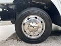 A close-up of a shiny chrome wheel with multiple bolts and a large black tire on a 2020 Freightliner MT45