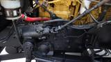 Close-up of the engine components of a 2003 International 5600i featuring various pipes and connectors along with a visible oil filter and a pump assembly