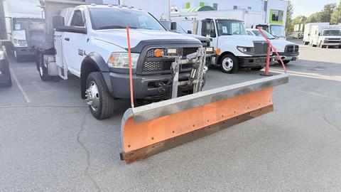 2016 RAM 5500 truck equipped with a large orange snow plow mounted on the front with metal blade and chains for snow removal