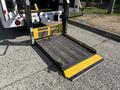 A 2018 Ford Transit-350 with a deployed wheelchair lift featuring a metal mesh platform and yellow safety markings