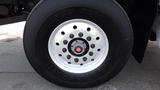 Close-up of a tire from a 2003 International 5600i featuring a silver wheel rim with multiple bolts and a central red hubcap