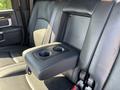 Rear seat center console of a 2018 RAM 3500 featuring two cup holders and a fold-down design