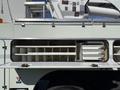 2008 International 7500 utility truck with an open storage compartment featuring several shelves and drawers for tools and equipment
