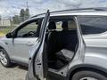 A 2015 Ford Escape with an open rear door revealing the interior seats and cabin space