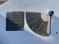 A metal gauge showing angles from 0 to 90 degrees with a mounting bracket attached displaying safety instructions for a vehicle's outriggers