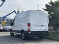 A white 2016 Ford Transit 150 van viewed from the rear with a high roof and large cargo space