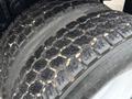 Close-up of a rugged tire from a 2012 International 7400 showcasing deep treads and wear patterns indicative of heavy use