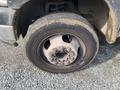 Close-up of a tire on a 2009 Dodge Ram 5500 showing the wheel rim and lug nuts with visible wear and dirt on the tread