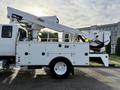 A 2013 International Durastar 4300 equipped with an Altec aerial lift boom and a service body with storage compartments on the side