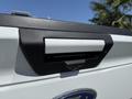 Close-up of the tailgate handle on a 2018 Ford F-150 featuring a sleek design and embossed vehicle logo
