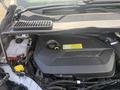 A 2014 Ford Escape engine compartment showing the engine cover coolant reservoir and various engine components