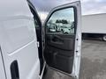 White 2022 GMC Savana van with an open driver's side door showing the interior handle and control panel