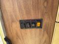 A vintage control panel from a 1976 GMC Motorhome featuring five switches labeled porch floor galley and water in a wooden frame