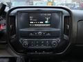 Dashboard of a 2017 GMC Sierra 3500HD displaying a touchscreen with radio information and control knobs for climate and media settings