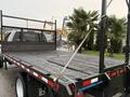 A 2008 Sterling Bullet flatbed truck with a wooden bed and a metal frame featuring a mesh guard and tie-down straps