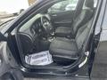 A black 2015 Dodge Charger with fabric seats and a clean interior showing two front seats and a floor mat
