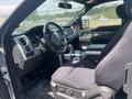 Interior of a 2014 Ford F-150 showing the driver's side seat and dashboard with controls and a gear shift