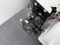 A black hydraulic control manifold with multiple fittings and valves attached to a white vehicle component