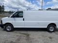 A white 2023 GMC Savana van is shown from the side with a smooth body and chrome wheels