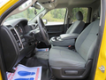Interior of a 2015 RAM 1500 showing two gray front seats and a center console with storage space