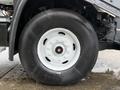 Close-up of a white rim and black tire on a 2016 Freightliner 108SD truck showcasing the tire tread and rim design