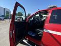 A red 2015 RAM 2500 with the driver's door open revealing the interior and dashboard