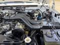 A 1995 Ford F-250 engine compartment showing various components including a black air intake tubing and several hoses and connectors