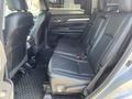 The interior of a 2018 Toyota Highlander showing the second row of black leather seats with a rubber floor mat