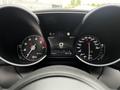 Dashboard of a 2023 Alfa Romeo Giulia showing speedometer and tachometer with a digital display in the center showing time and temperature