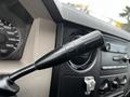 A close-up of the gear shift lever in a 2009 Ford F-550 featuring a black textured handle and dashboard controls adjacent to it