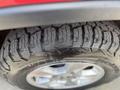A close-up of a rugged tire on a 2015 Jeep Grand Cherokee showcasing deep treads designed for off-road performance