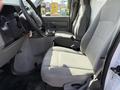 Interior view of a 2019 Ford Econoline showing the driver's and passenger's gray upholstered seats and part of the dashboard without any occupants
