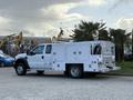A white 2008 Ford F-450 with a utility body featuring multiple storage compartments and toolboxes on the sides